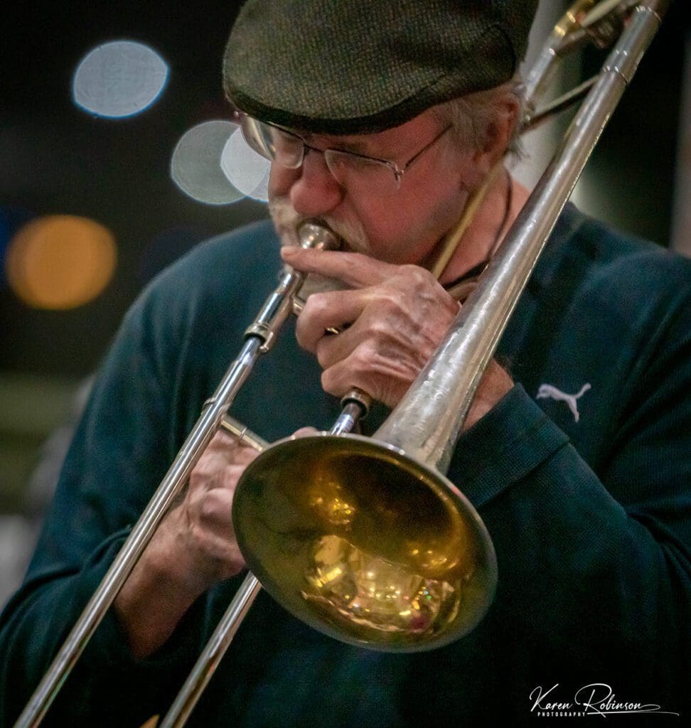 A man playing trombone in the street.