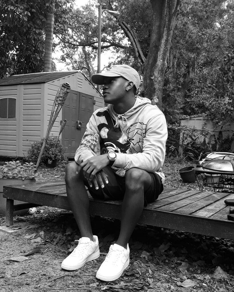 A man sitting on top of a wooden deck.