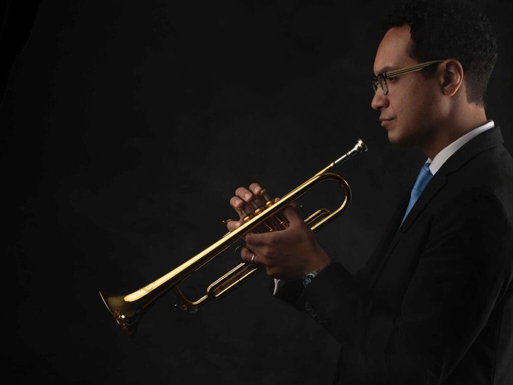 A man in a suit and tie playing the trumpet.