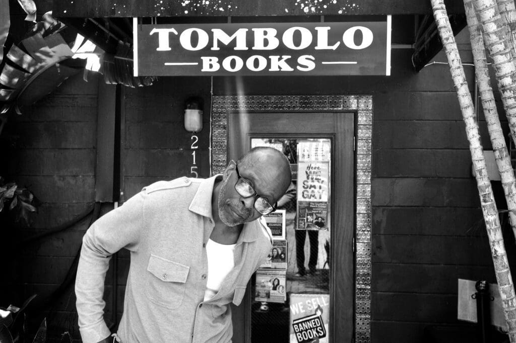 A man standing in front of a bookstore.