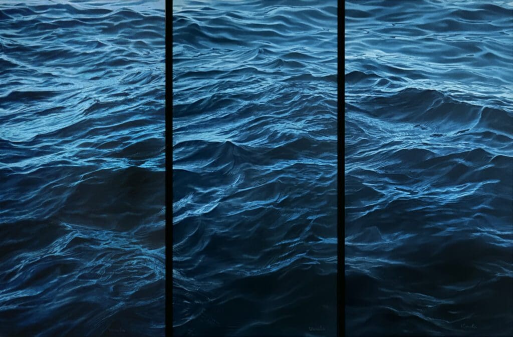 A blue ocean with waves and a black pole