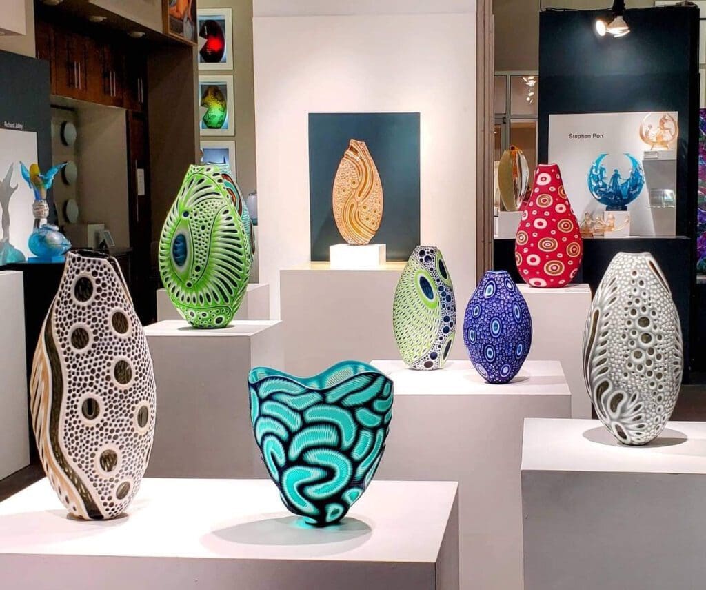 A group of colorful vases on display in a room at Duncan McClellan Gallery