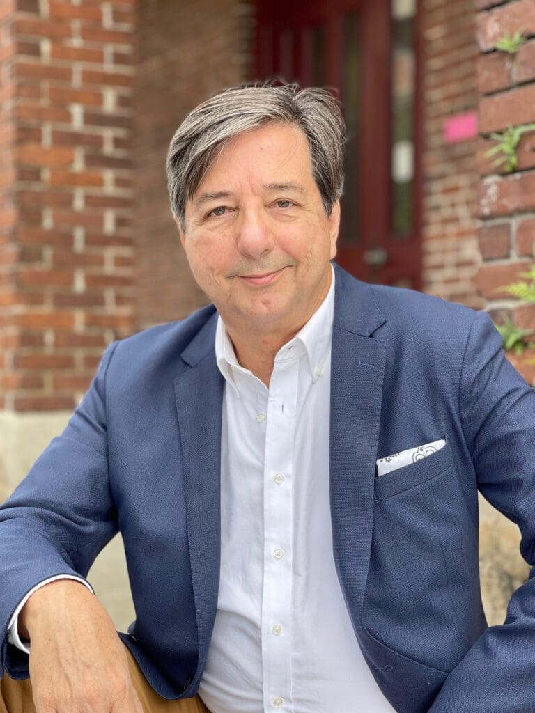 A man in a suit sitting on the ground.