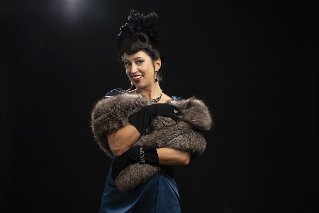 A woman in a fur coat and hat posing for the camera.