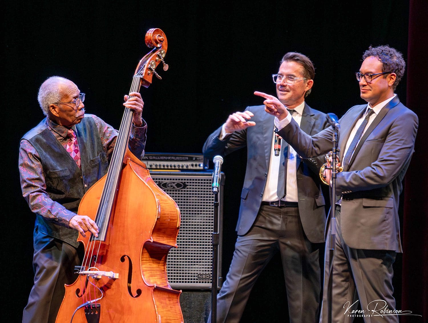 A group of people standing on stage with instruments.